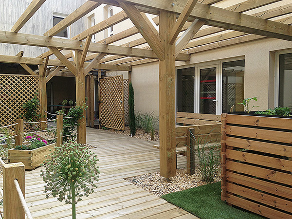 Au milieu du bâtiment, le patio avec un aménagement en bois, une atmosphère chaleureuse pour se resourcer