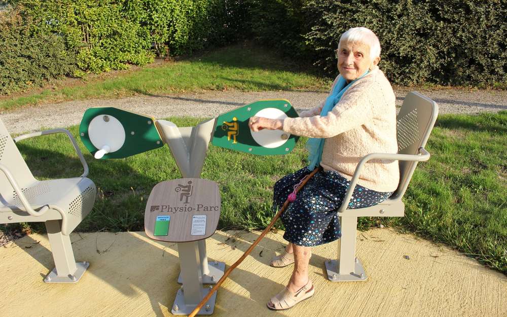 Une personne âgée fait de l'exercice avec un "médalier", en faisant des moulinets avec les mains